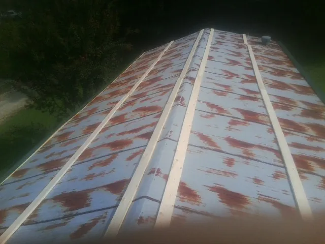 Rusted metal roof panels with new wood purlins before replacement — Storm Damage Roof Repair in Marietta by Roofing Brothers