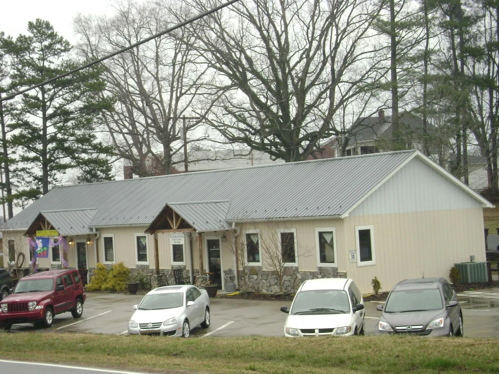 Gray metal roof with timber entry brackets on a small commercial building in Marietta
